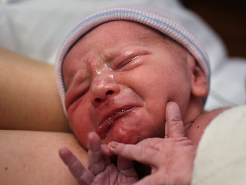 A newborn baby girl is reunited with her mother straight after birth in a hospital environ