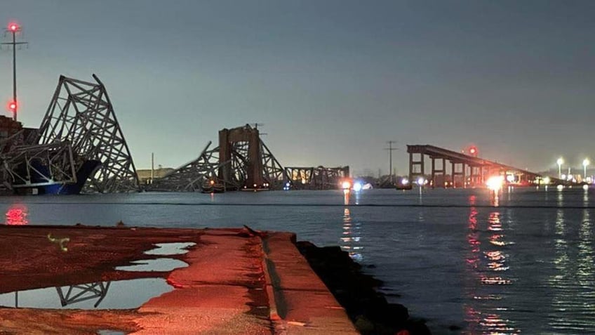 Baltimore bridge collapsed in the background as emergency vehicles are seen in the foreground