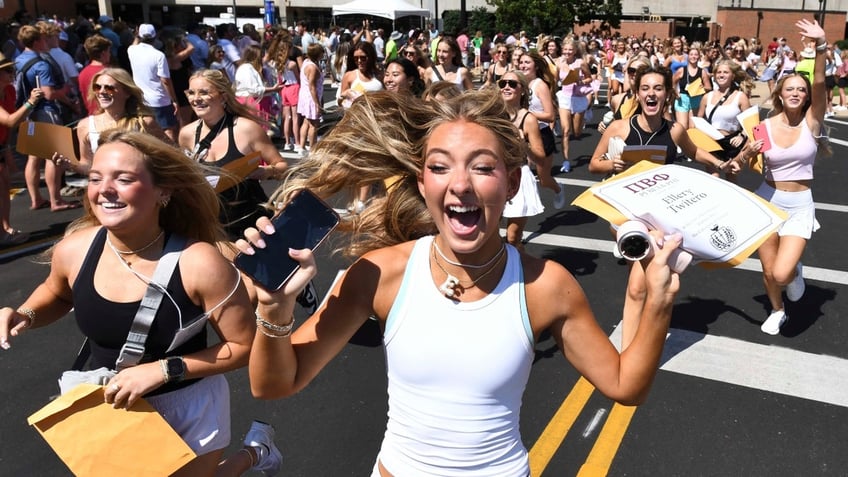 New Pi Beta Phi member Ellery Twitero runs from Bryant-Denny Stadium to her new house with others who are new members of the sorority.