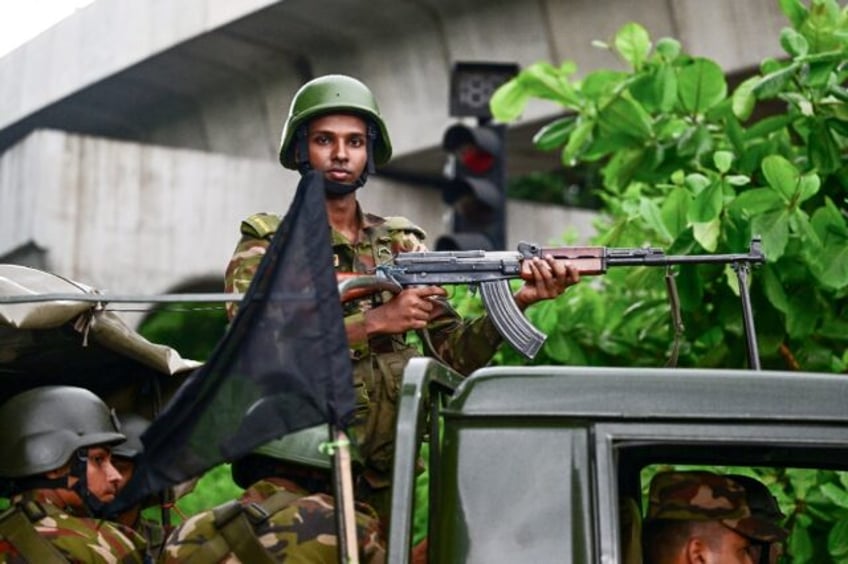 Bangladesh soldiers stand guard in Dhaka near a black flag after the government called for