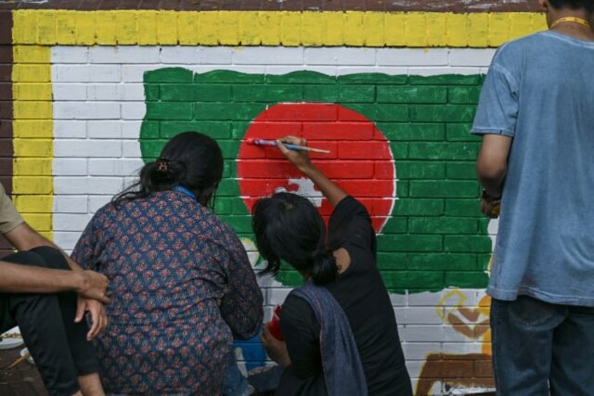 Students paint a mural in the colours of the Bangladesh national flag days after the ouste