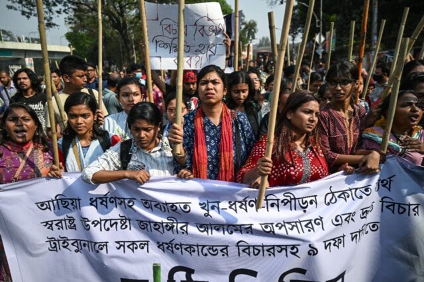 Women activists holding bamboo sticks take part in a demonstration in Dhaka to condemn rap