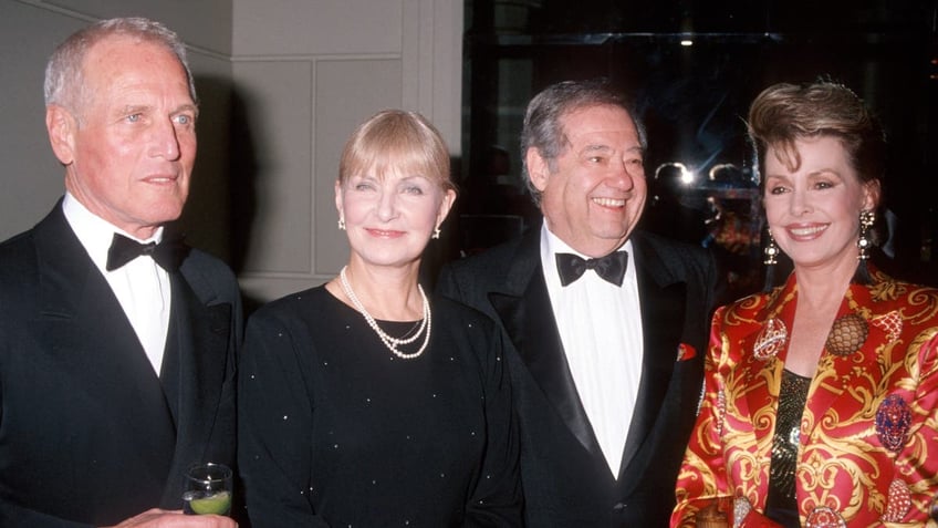 Paul Newman, Joanne Woodward, Warren Cowan and Barbara Rush smiling for the camera together.