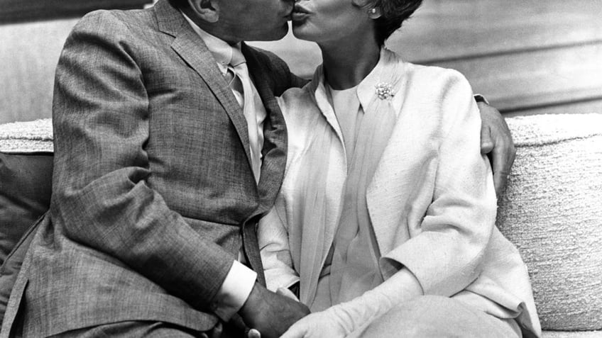 Frank Sinatra and Barbara Rush kissing while filming a movie.