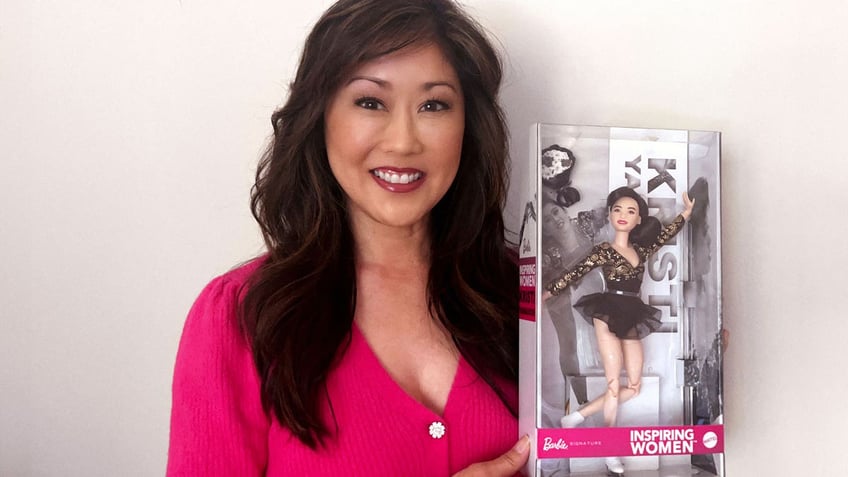 Figure skater Kristi Yamaguchi holds up a Barbie doll based on herself.