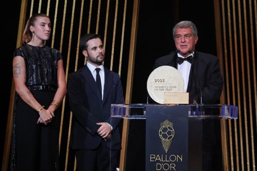 Jonatan Giraldez (C) on stage as Barcelona receive the women's club of the year trophy during the 2023 Ballon d'Or award ceremony