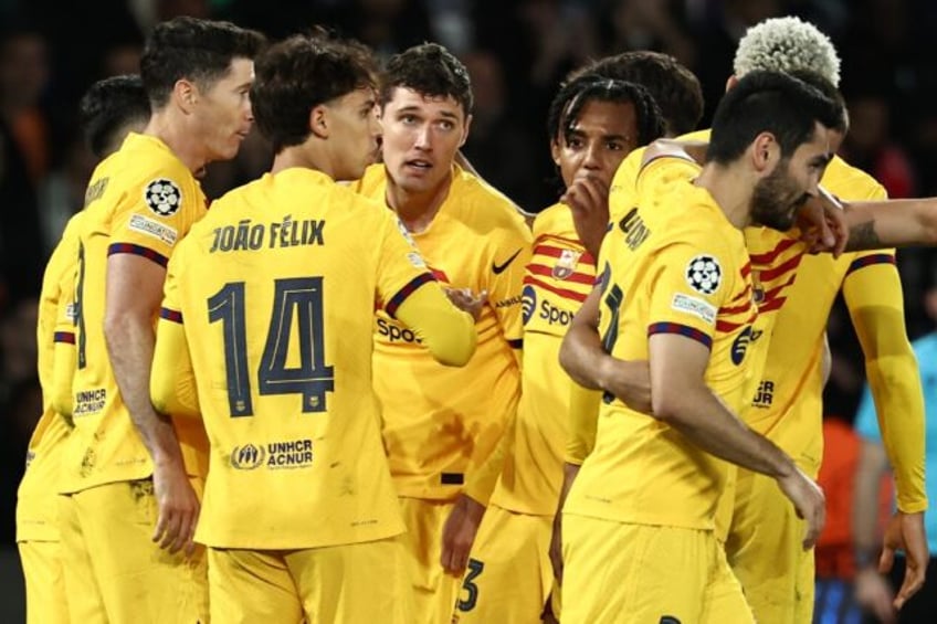 Barcelona players celebrate after Andreas Christensen (C) put them 3-2 up against PSG in t