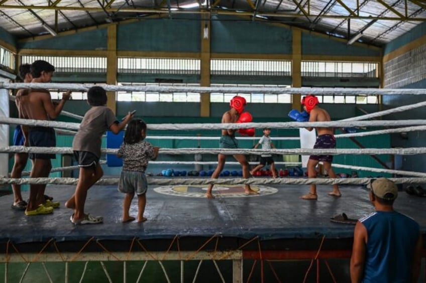 Young boxers train at the gym in Bago City under the buzz of old electric fans straining t