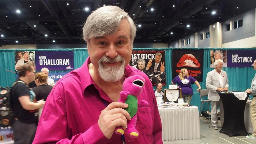 Bob West holding Barney toy