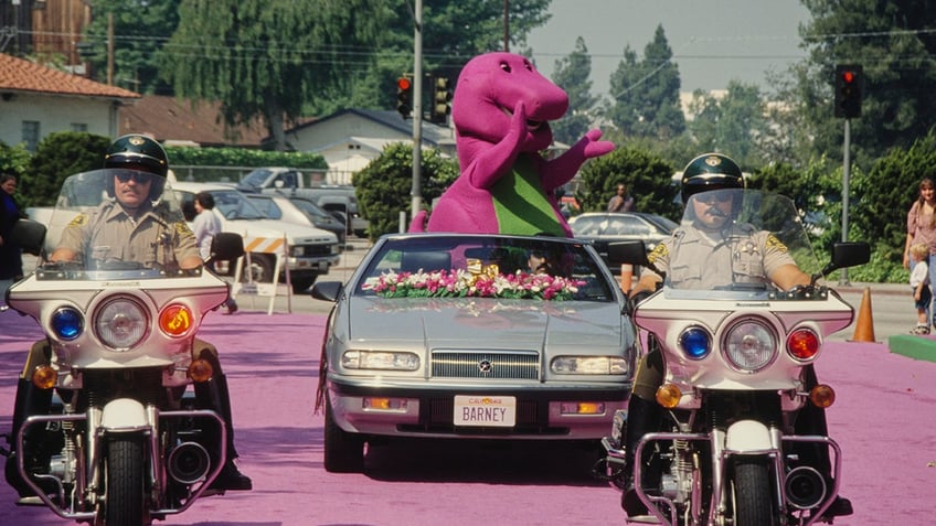 barney the dinosaur riding in a motorcade