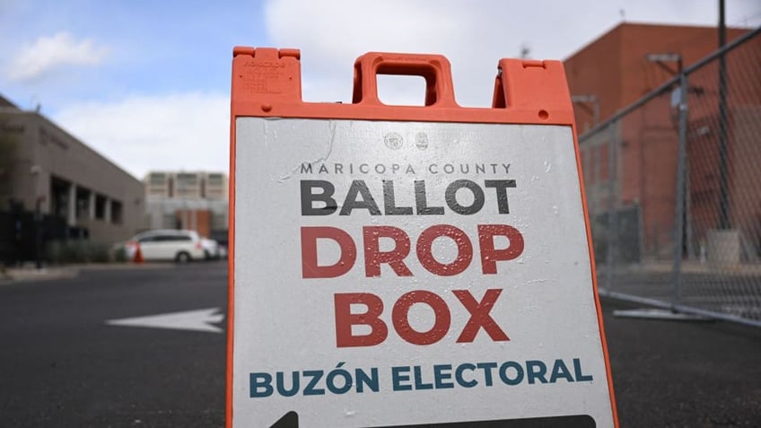 Signage directs voters to a ballot drop box for early voting outside of the Maricopa County Tabulation and Election Center ahead of the Arizona midterm elections in Phoenix, Arizona on November 3, 2022. 