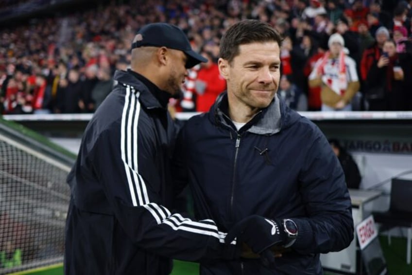 Bayern Munich coach Vincent Kompany (L) greets Bayer Leverkusen coach Xabi Alonso. The two