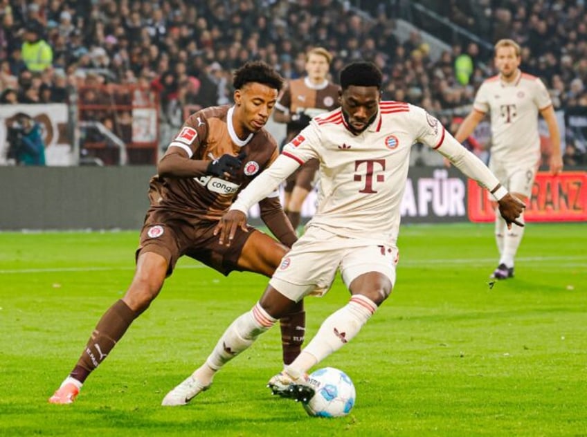 Bayern Munich defender Alphonso Davies, R, has signed a five-year extension with the club.