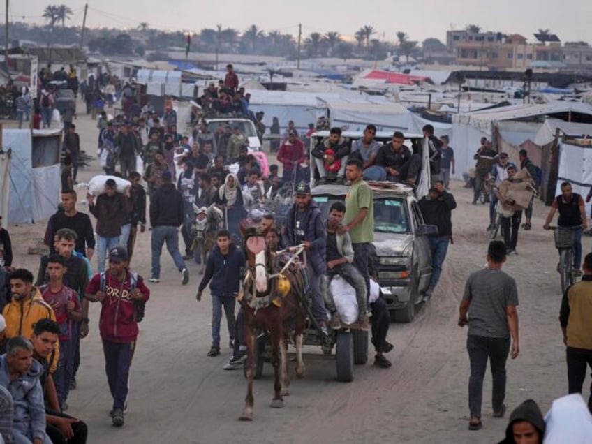Palestinians carry bags filled with food and humanitarian aid provided by the Gaza Humanit