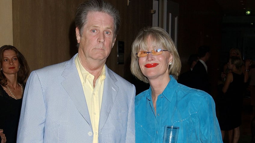 Brian Wilson and Melinda Wilson walk a red carpet