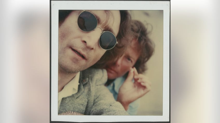 Polaroid of John Lennon and Elliot Mintz posing for a photo.