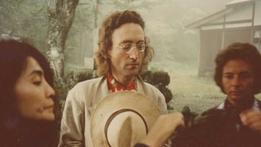 A close-up of Yoko Ono, John Lennon and Elliot Mintz standing together.