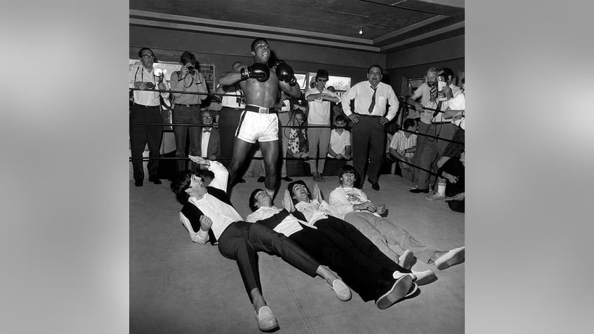 Muhammad Ali towering over the Beatles on the floor