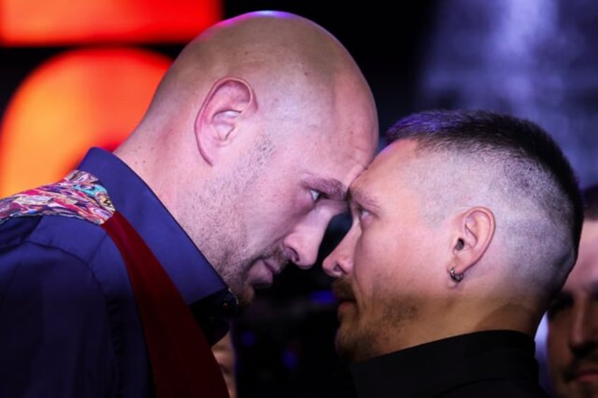 Britain's Tyson Fury (L) and Ukraine's Oleksandr Usyk (R) challenge each other during a pr