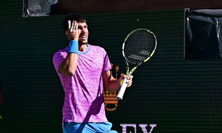 Spain's Carlos Alcaraz reacts to a swarm of bees that halted play in his ATP-WTA Indian We