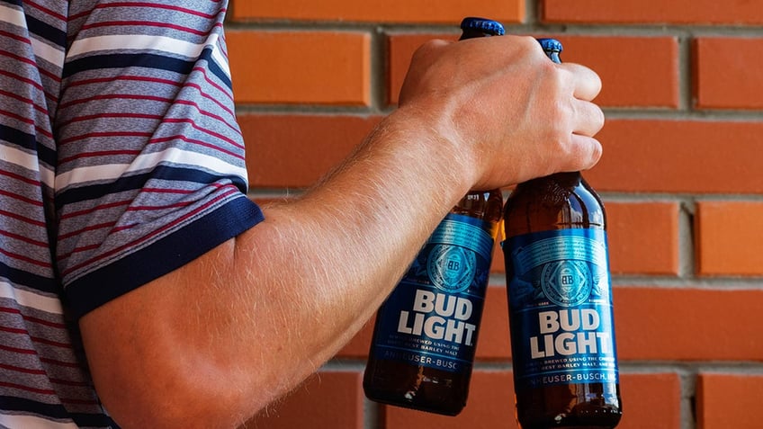 man holding bud light bottles