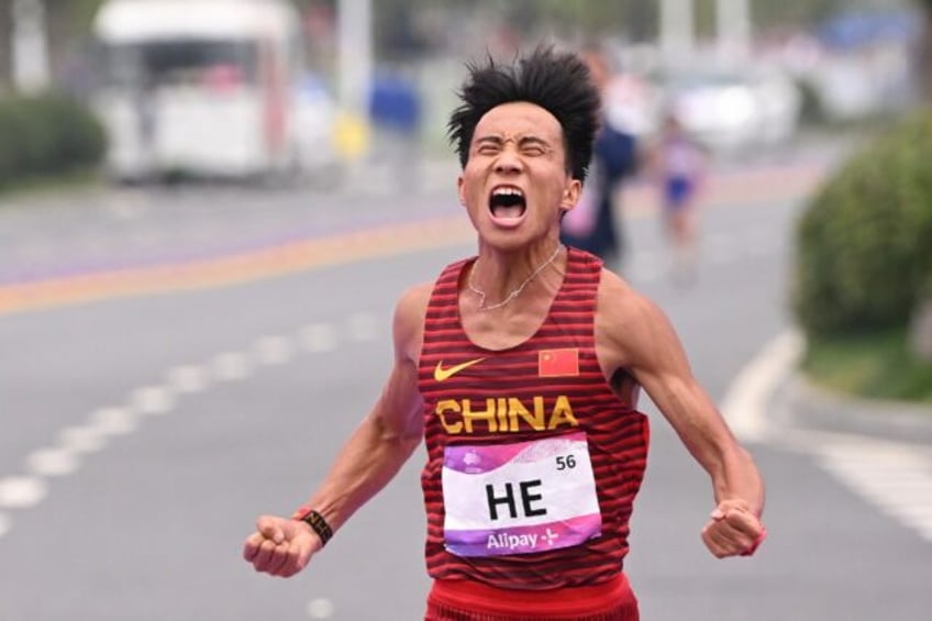 China's He Jie celebrates after winning the Asian Games marathon title