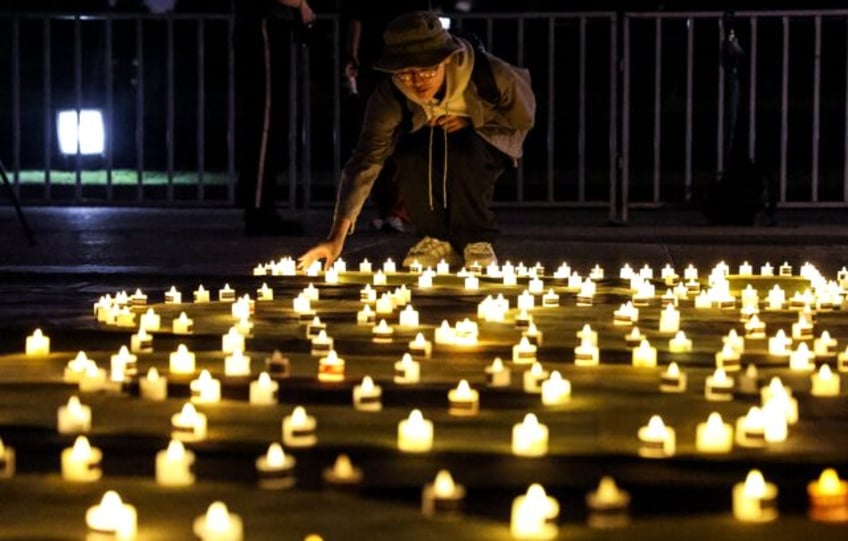 A mourner places a candle at Taipei's Liberty Square to mark the 36th anniversary of China