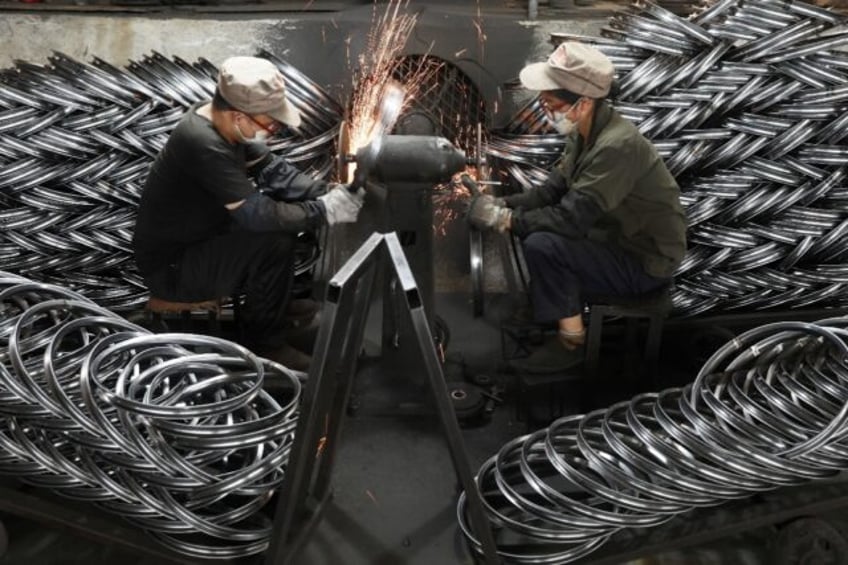 Workers polish bicycle wheels at a factory in Hangzhou, in China’s eastern Zhejiang prov