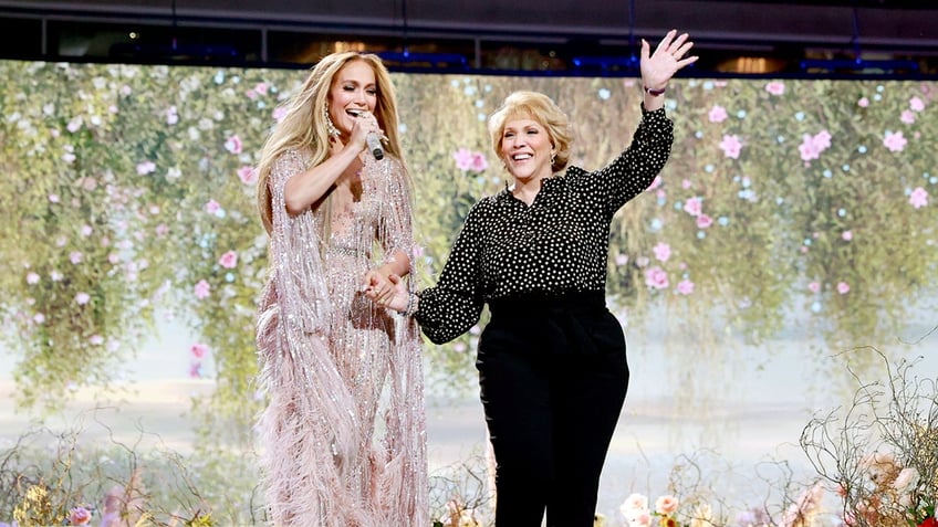 Jennifer Lopez posing on stage with her mom Guadalupe Lopez