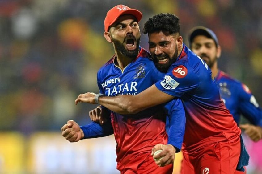 Centre of attention: Virat Kohli (L) celebrates after taking a catch to dismiss Daryl Mitc