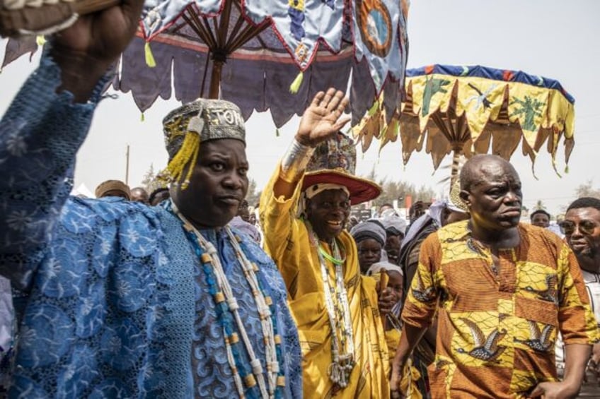 The traditional leader of the Voodoo cult, His majesty Daagbo Hounon Houna II (C), greets the crowd during the festival