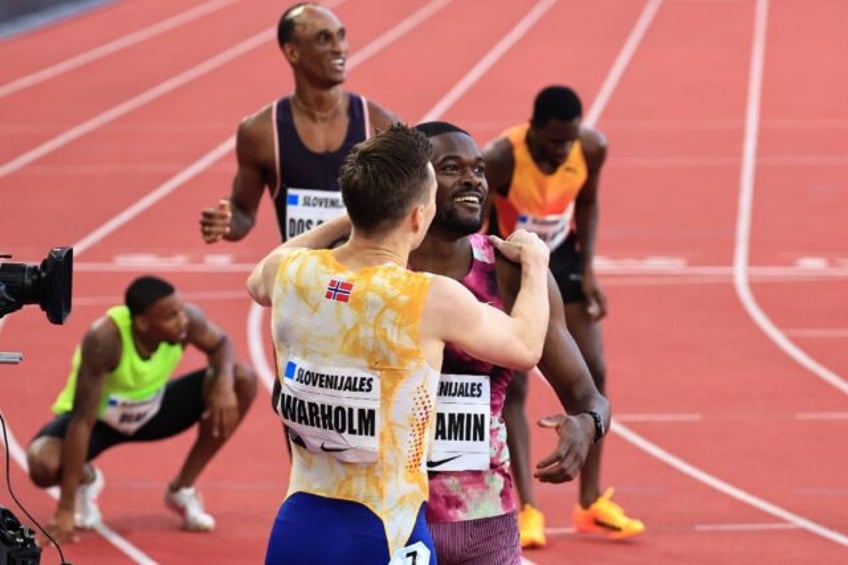 Norway's Karsten Warholm and American Rai Benjamin (C) react after the men's 400m hurdles