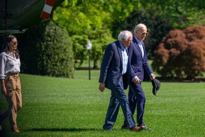 US President Joe Biden walks with Senator Bernie Sanders on the South Lawn of the White Ho