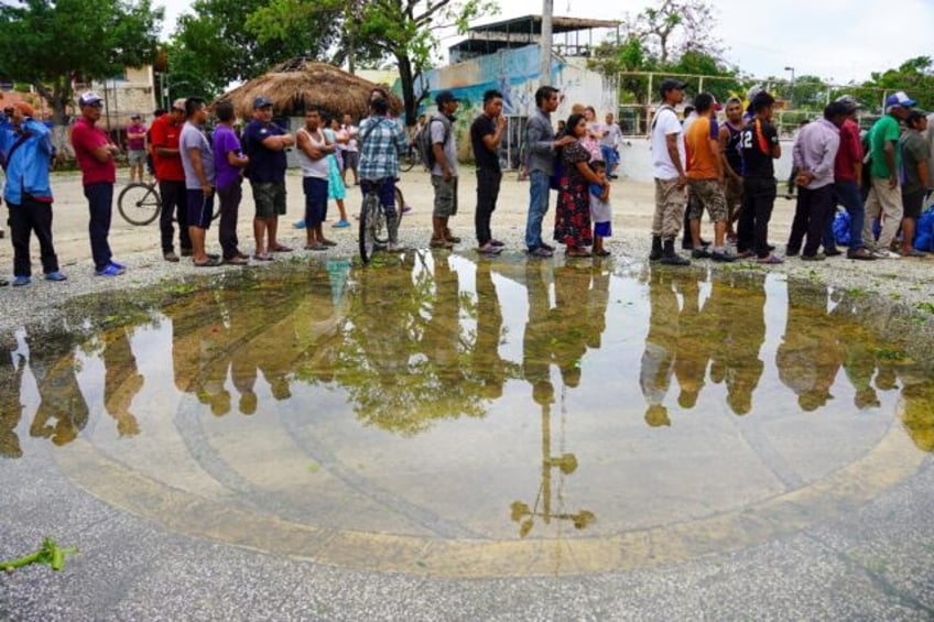 Residents in Tulum, Mexico, queue to receive food rations provided by the Mexican army fol