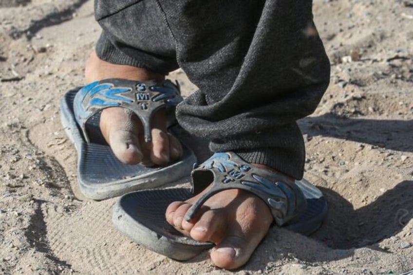 A Palestinian shows his worn-out shoes in Khan Yunis in the southern Gaza Strip