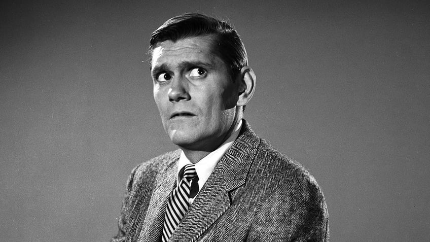 A close-up of Dick York in a suit looking concerned.