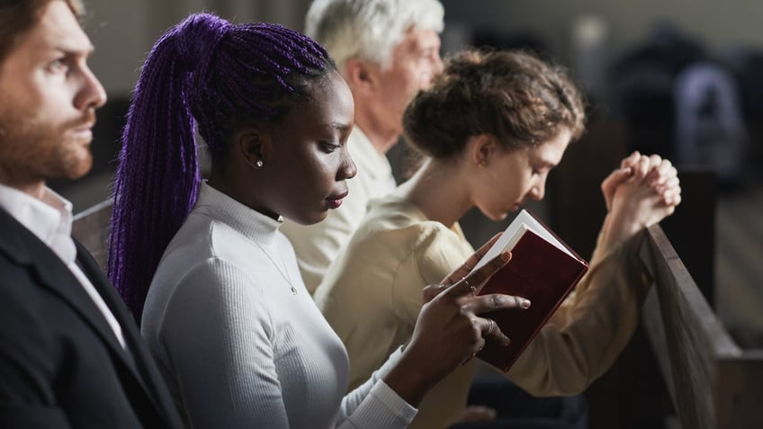 people praying in church pew