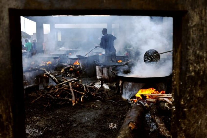 Cooks work over open fires in Kivukoni fish market in Dar es Salaam, Tanzania