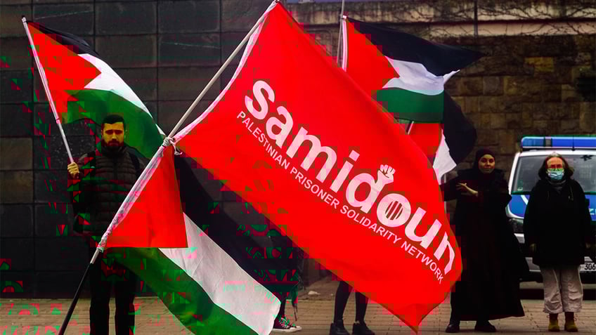Protestors holding up the Samidoun flag.