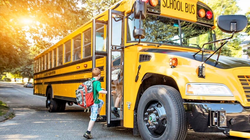 A child getting on a school bus