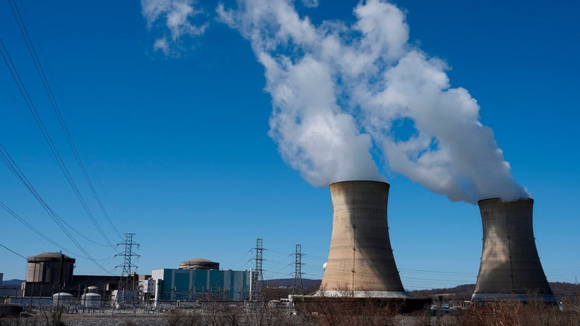 Power lines come off of the nuclear plant on Three Mile Island, with the operational plant run by Exelon Generation on the right, in Middletown, Pennsylvania, on March 26, 2019.