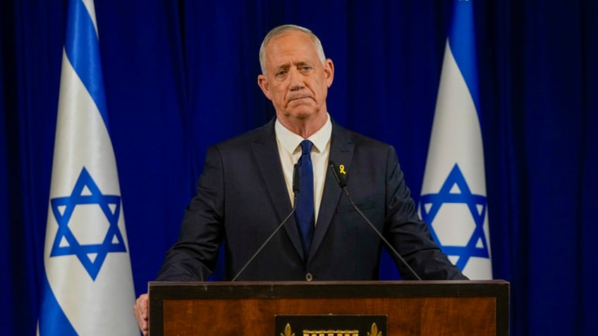 Benny Gantz stands next to Israeli flags