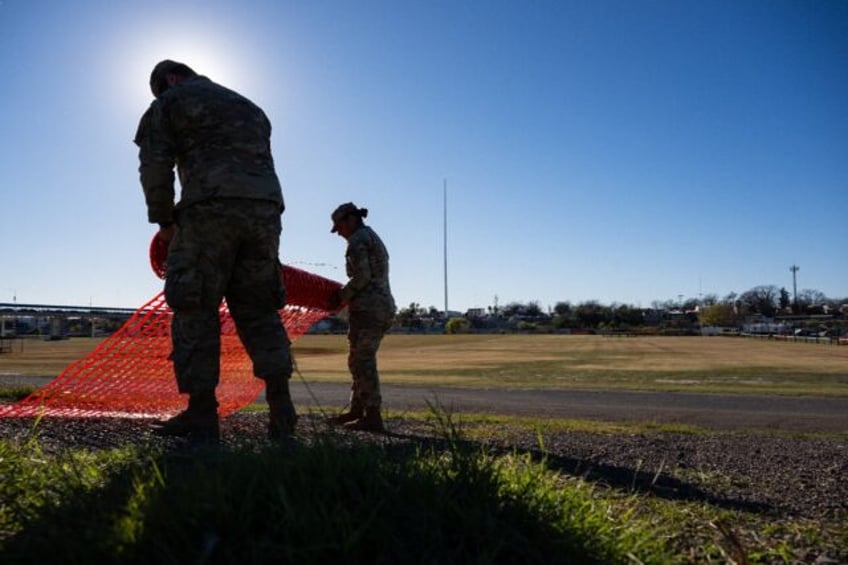 National Guard soldiers roll up fencing on the banks of the Rio Grande river at Shelby Park on January 12, 2024 in Eagle Pass, Texas