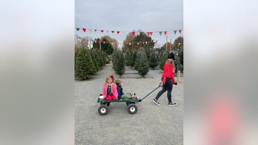 Kelsey Bolar's children ride in a wagon pulled by her au pair.