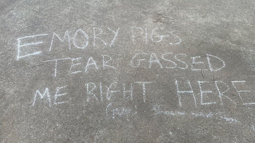 A message written in chalk that says Emory pigs tear gassed me right here