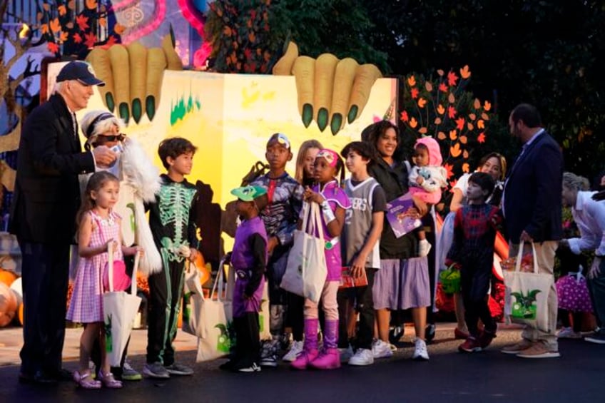 biden and jill biden hand out books and candy while hosting thousands for rainy trick or treating