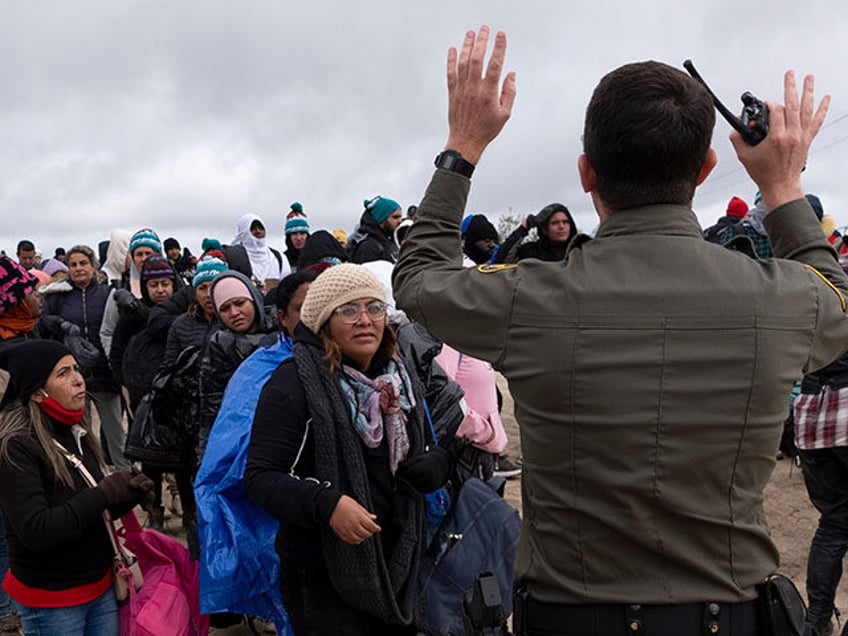 Peruvian Julia Paredes, left in white hat, listens to instructions from a Border Patrol ag