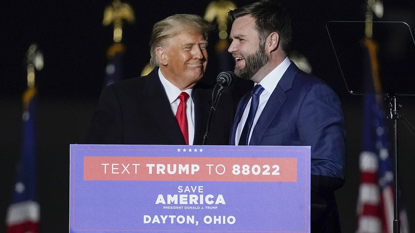 JD Vance talks on stage with former US President Donald Trump