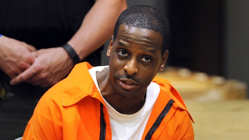 Russell Peeler Jr. wearing orange prison jumpsuit in court