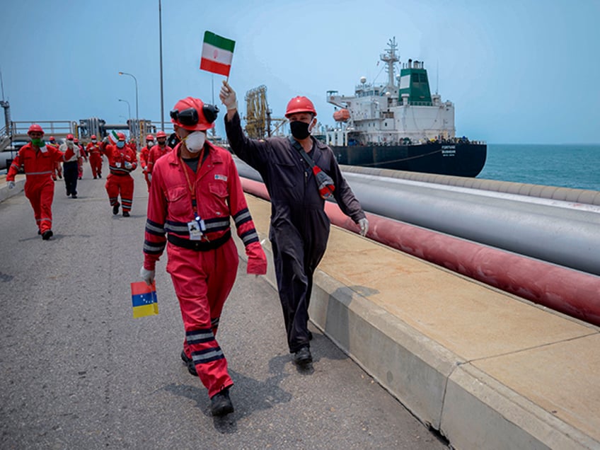 A worker of the Venezuelan state oil company PDVSA waves an Iranian flag as the Iranian-flagged oil tanker Fortune docks at the El Palito refinery in Puerto Cabello, in the northern state of Carabobo, Venezuela, on May 25, 2020. - The first of five Iranian tankers carrying much-needed gasoline and oil derivatives docked in Venezuela on Monday, Caracas announced amid concern in Washington over the burgeoning relationship between countries it sees as international pariahs. (Photo by - / AFP) (Photo by -/AFP via Getty Images)